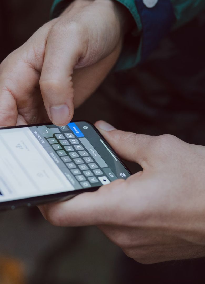 Close-up of hands typing on a smartphone with on-screen keyboard visible- Neutrinos