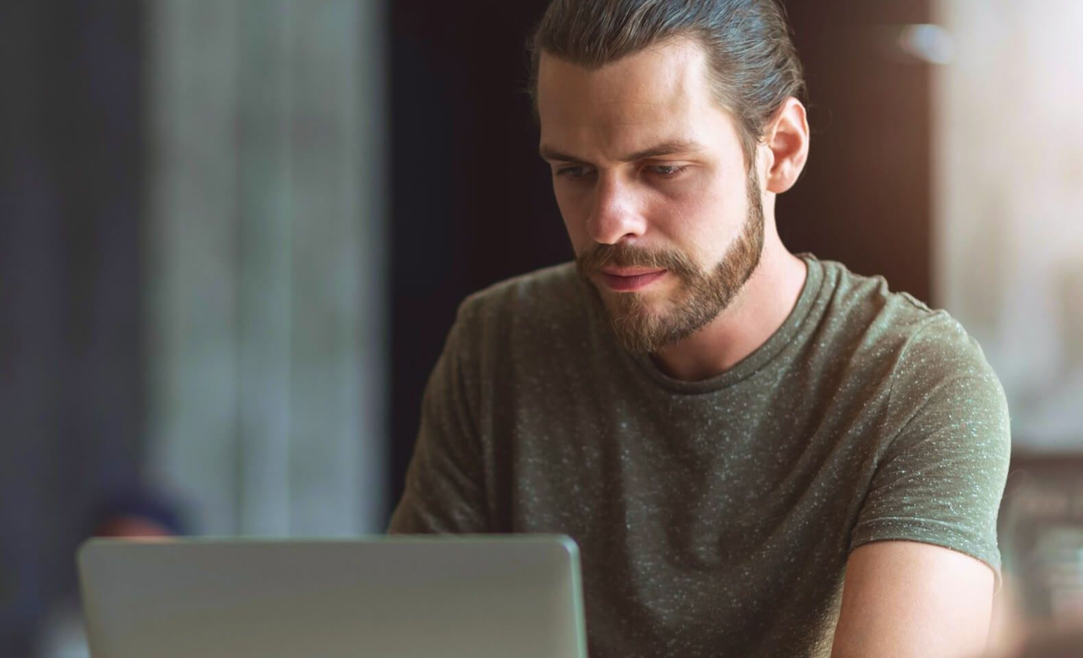 Professional young man using a laptop in a modern workspace – Neutrinos