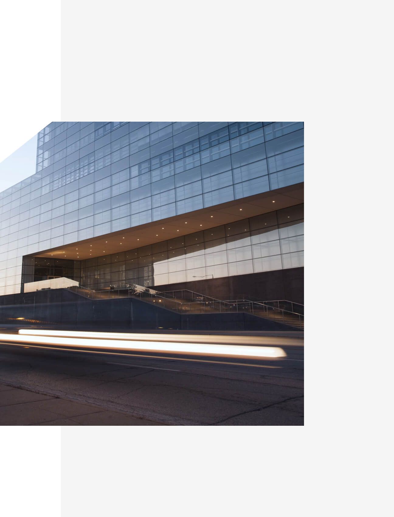 Glass office building with light trails from passing vehicle - Neutrinos