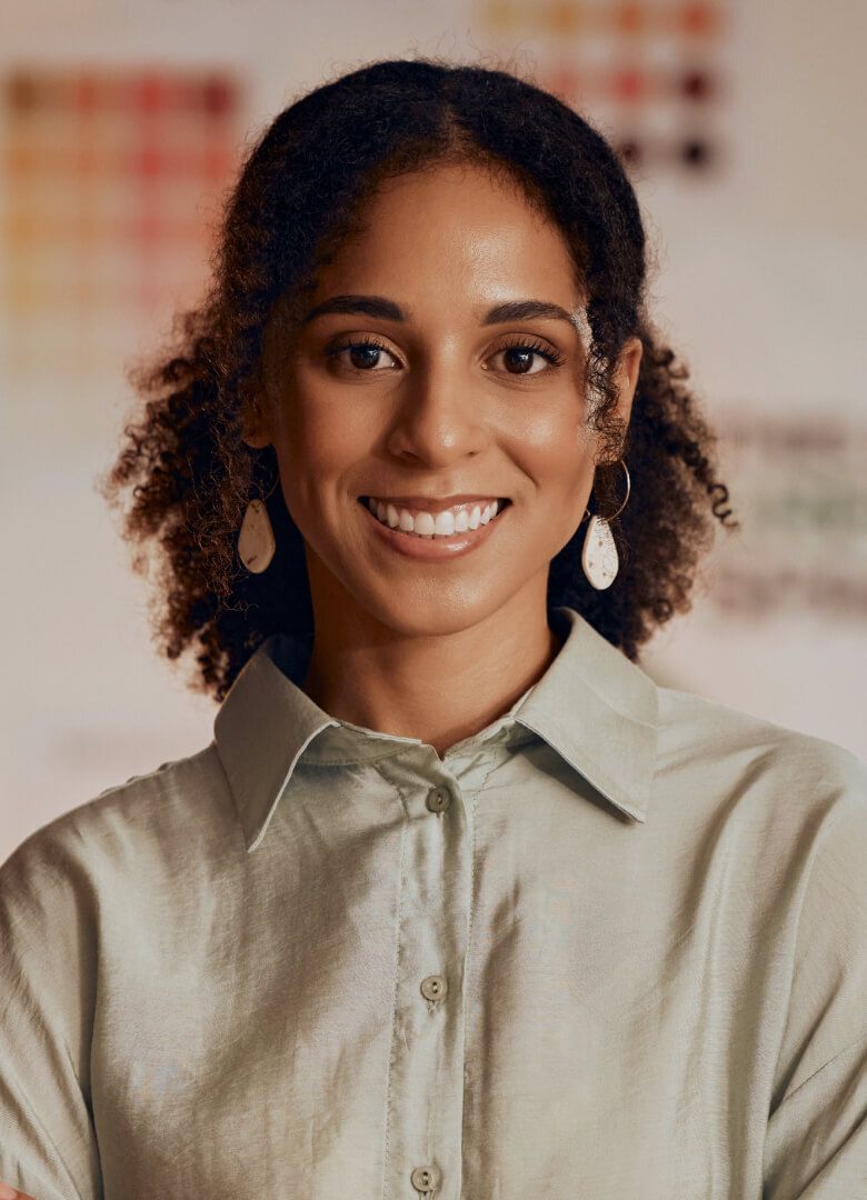 Smiling professional woman in a button-up shirt at a corporate event- Neutrinos